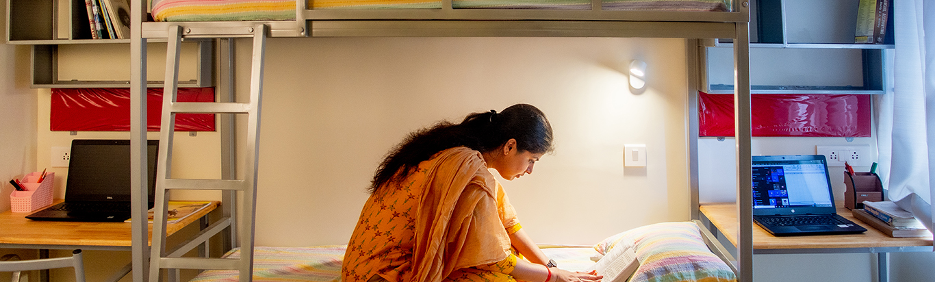 Student reading a textbook at Rani Meyyammai Hostel